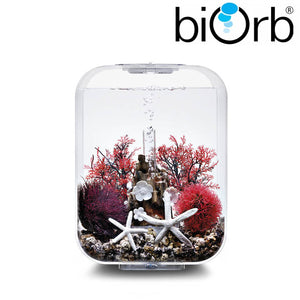biOrb LIFE 15 l. i transparent. Dekoreret med blomster på stub ornament, mørkerøde koraller, lilla og mørkerød plante kugle og hvide søstjerner. 72047 72050